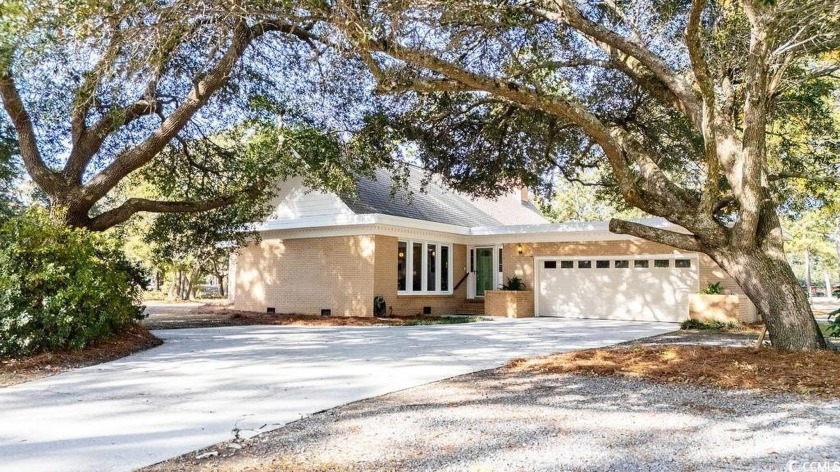 Set on over an acre of beautifully landscaped grounds, this - Beach Home for sale in Pawleys Island, South Carolina on Beachhouse.com