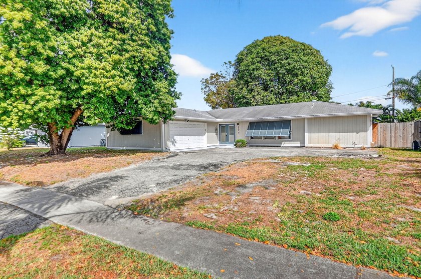 Welcome to this charming 4-bedroom, 2-bathroom home with a 2-car - Beach Home for sale in Palm Springs, Florida on Beachhouse.com