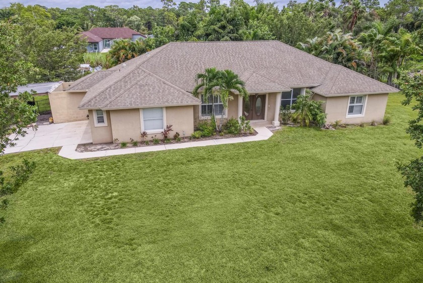 Located in The Acreage, this charming 4-bedroom, 2-bath home - Beach Home for sale in West Palm Beach, Florida on Beachhouse.com