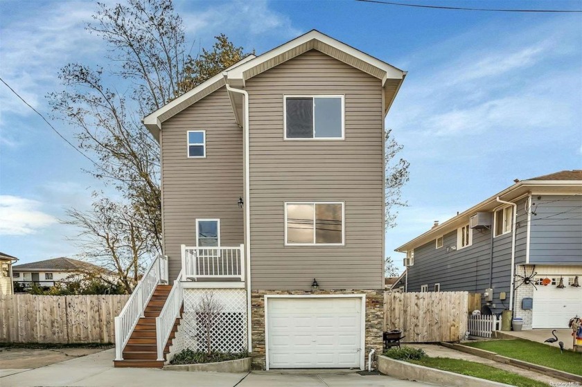 Nestled along the serene waterfront, this exquisite 4-bedroom, 4 - Beach Home for sale in Island Park, New York on Beachhouse.com