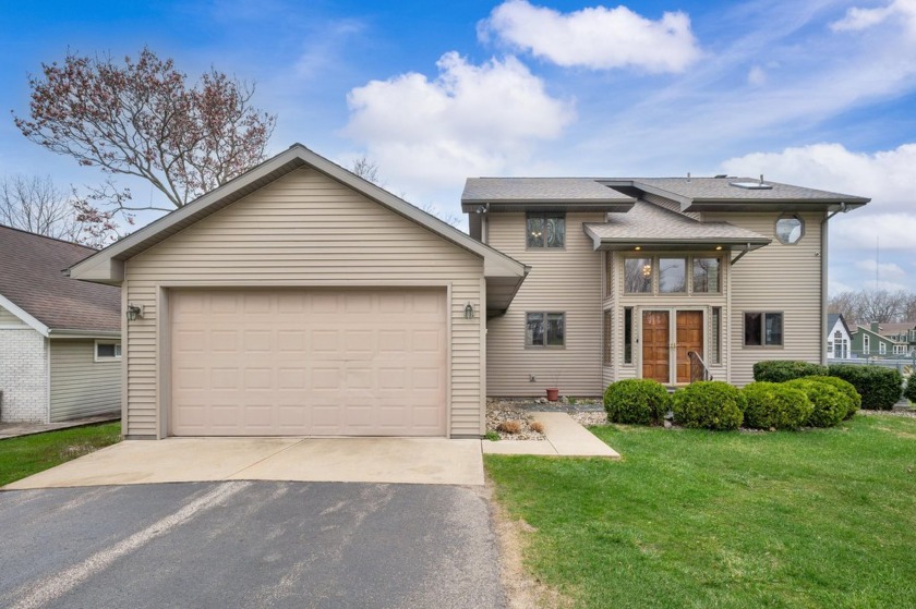 Tucked along the peaceful channel of Paw Paw Lake, this - Beach Home for sale in Coloma, Michigan on Beachhouse.com