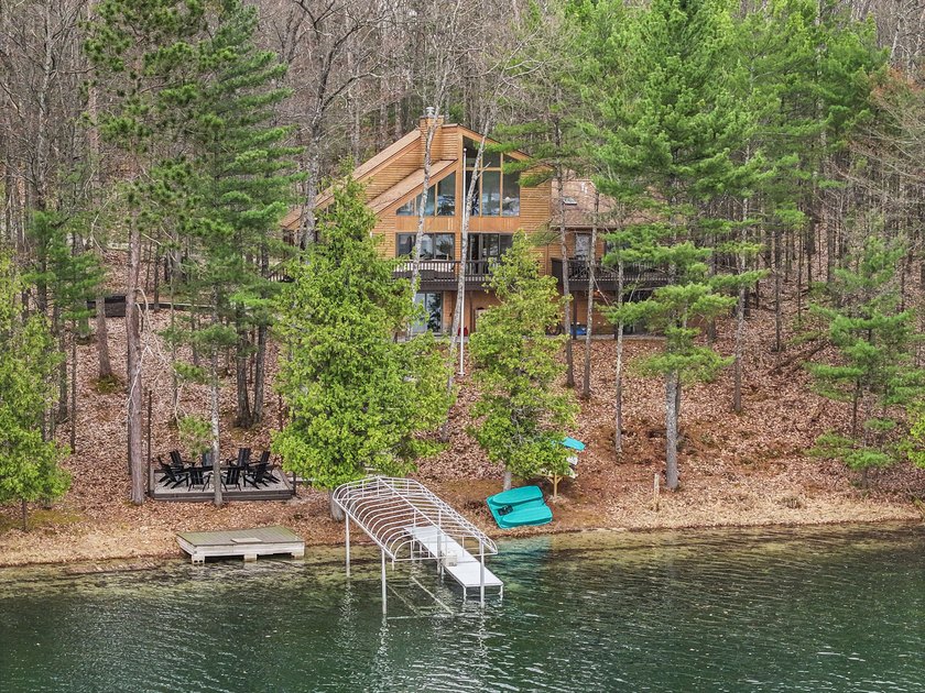 LAKEFRONT RETREAT! Hidden among mature trees and set along 200 - Beach Home for sale in Traverse City, Michigan on Beachhouse.com