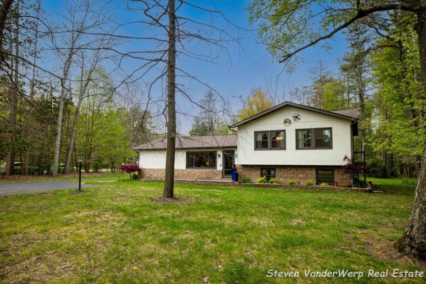 Set on 1.5 wooded acres in beautiful West Olive, this 4-bedroom - Beach Home for sale in West Olive, Michigan on Beachhouse.com