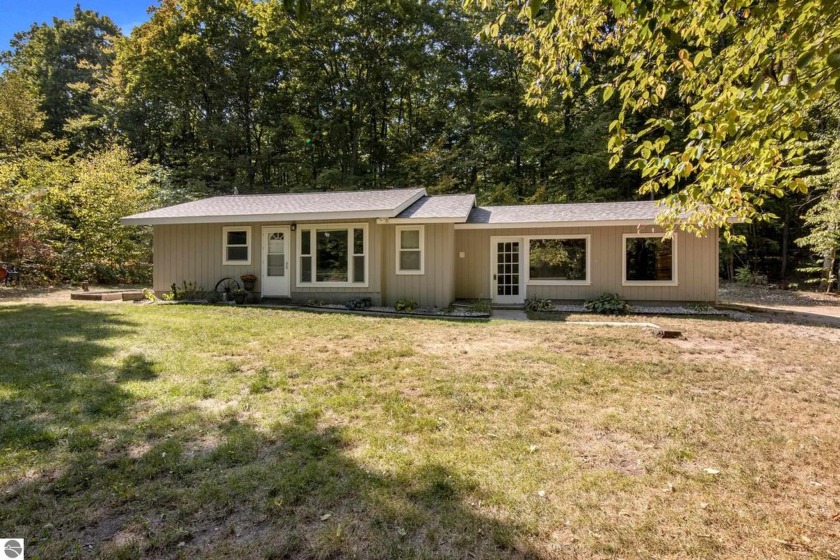 Nestled on 1.41 acres of wooded privacy, this cozy, little home - Beach Home for sale in Maple City, Michigan on Beachhouse.com