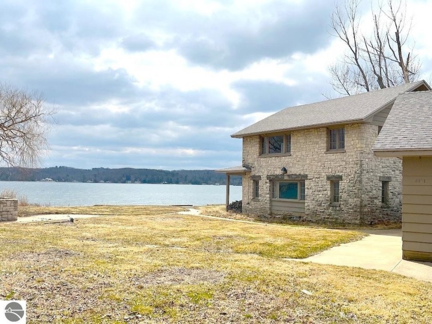 Prime frontage on beautiful Portage Lake! This rare offering on - Beach Home for sale in Onekama, Michigan on Beachhouse.com