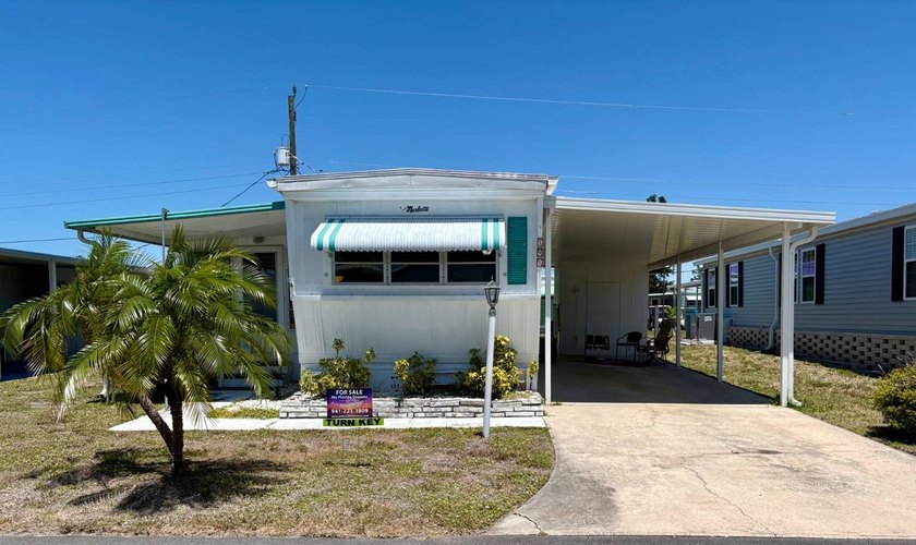 Framed by a miniature palm and bordered by mature plantings - Beach Home for sale in Nokomis, Florida on Beachhouse.com