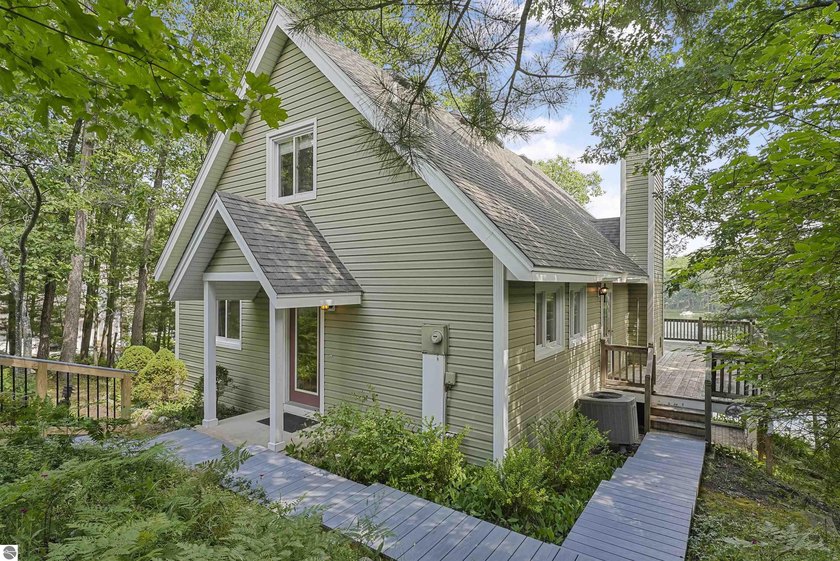 Tucked along 100 feet of private, sandy frontage on all-sports - Beach Home for sale in Traverse City, Michigan on Beachhouse.com