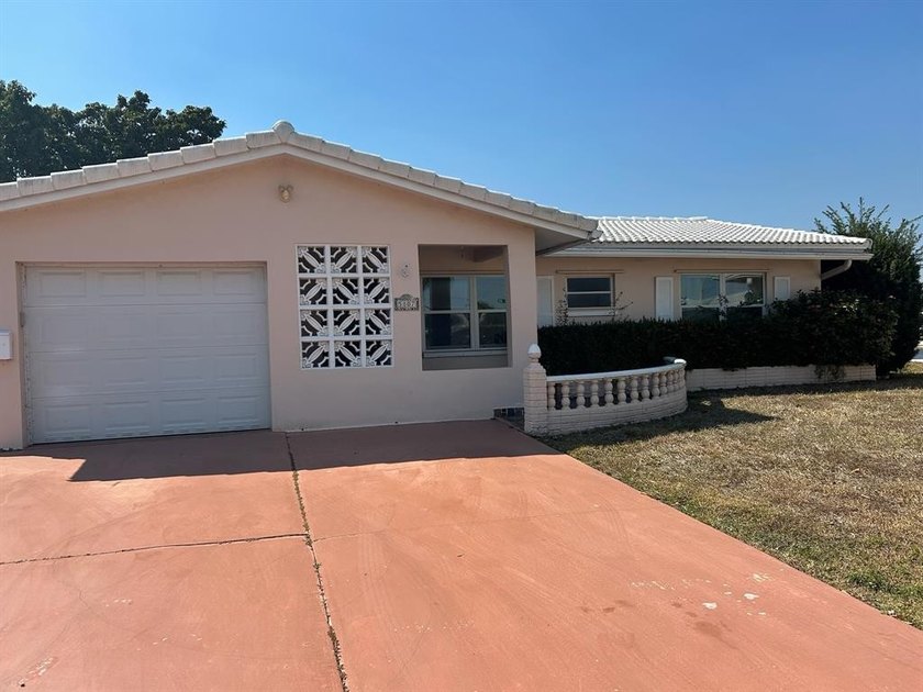 This charming single-family home offers serene water views and - Beach Home for sale in Tamarac, Florida on Beachhouse.com