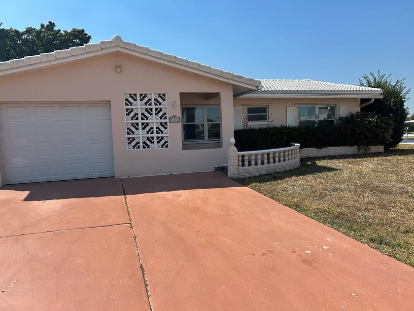 This charming single-family home offers serene water views and - Beach Home for sale in Tamarac, Florida on Beachhouse.com