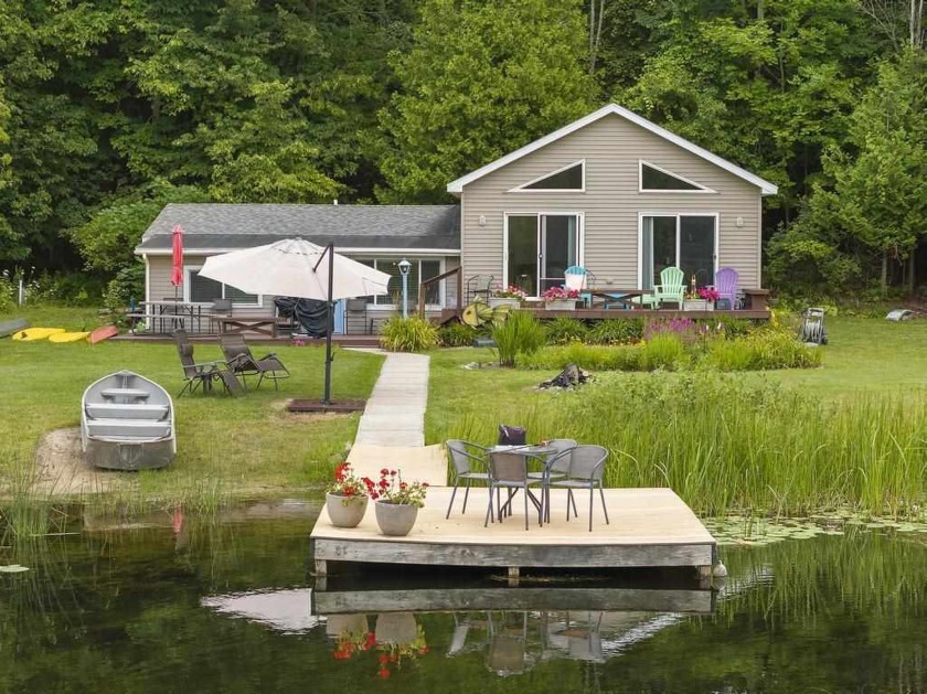 Nestled on a serene riverbank with 450 feet of waterfront access - Beach Home for sale in Ellsworth, Michigan on Beachhouse.com