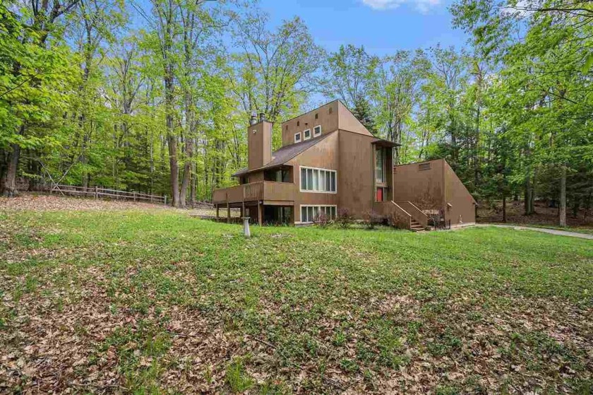 Nestled on a serene, wooded lot and backing up to protected - Beach Home for sale in Harbor Springs, Michigan on Beachhouse.com