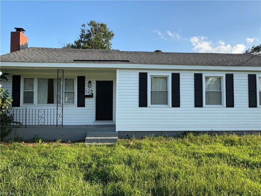 Open living room is enhanced by a classic wood fireplace and - Beach Home for sale in Portsmouth, Virginia on Beachhouse.com