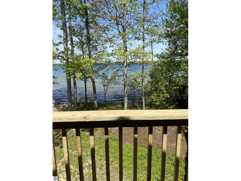 This lake front home boasts 100 feet of private frontage on - Beach Home for sale in Elk Rapids, Michigan on Beachhouse.com